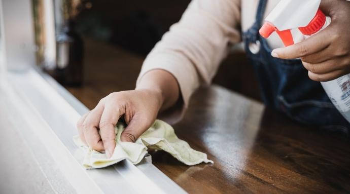 Spray Bottle Use Image of person wiping window sill