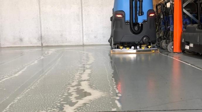 Degreaser industrial cleaner on floor being cleaned by scrubbing machine Degreaser industrial cleaner on floor being cleaned by scrubbing machine